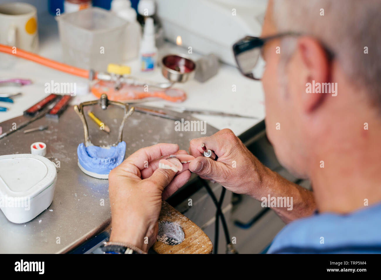 Caucasian man working on a dental prosthesis Stock Photo