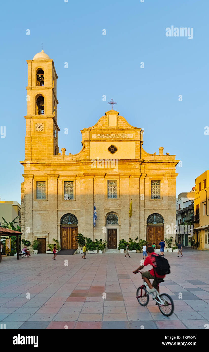 Crete, Greece - 07/24/2009: Boy on bicycle and children playing in front of Greek Orthodox Cathedral on Plateia Mitropoleos Square called Church of th Stock Photo