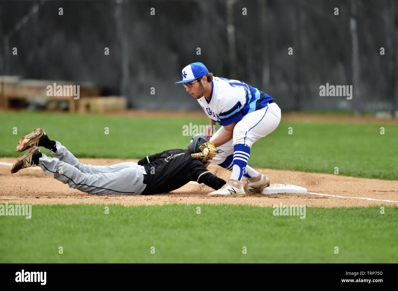 Base runner diving back to first base safely on a pick off throw from