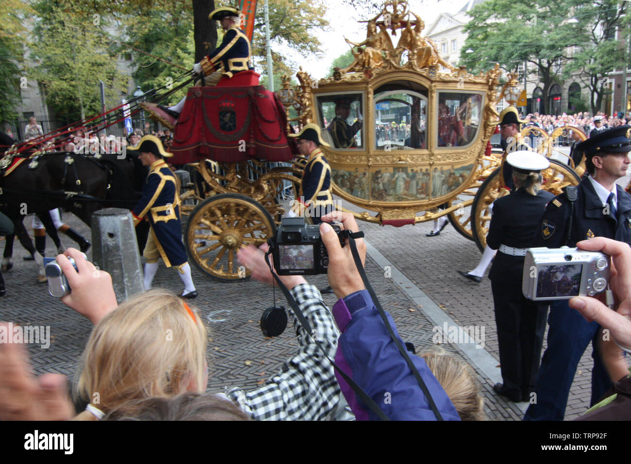 People were gathering alongside the street and taking photos when Queen Beatrix on the golden carriage was passing by at Prinsjesdag procession Stock Photo