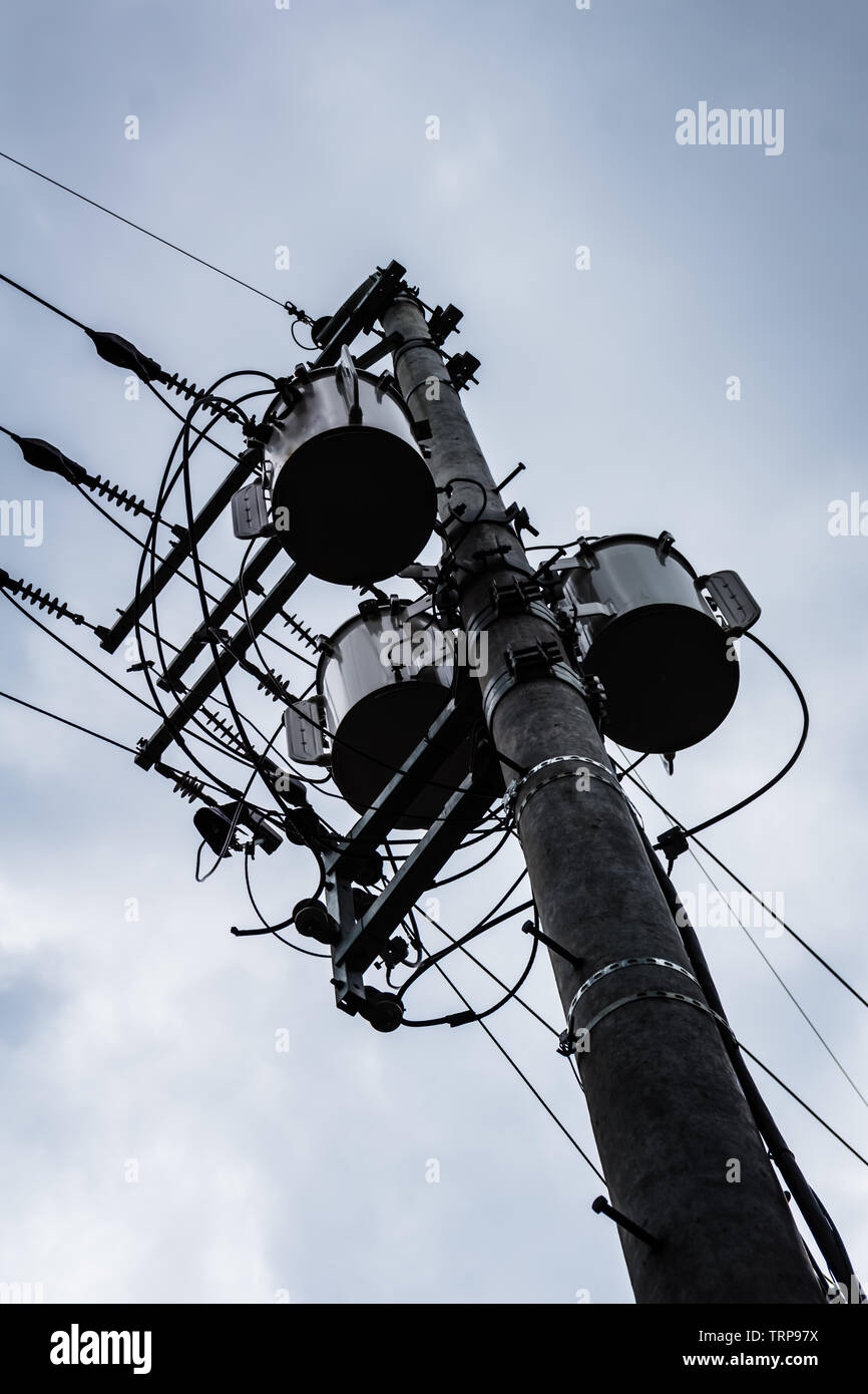Isolated Electrical Pole With Transformers And Wires Against A Cloudy 