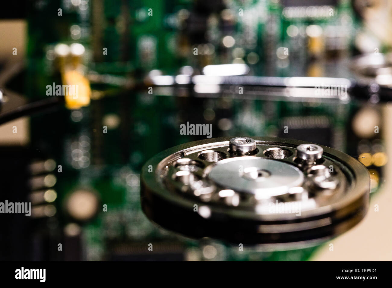Controller circuit board and hard drive spindle and head actuator in a macro close up of a disassembled hard drive. Stock Photo