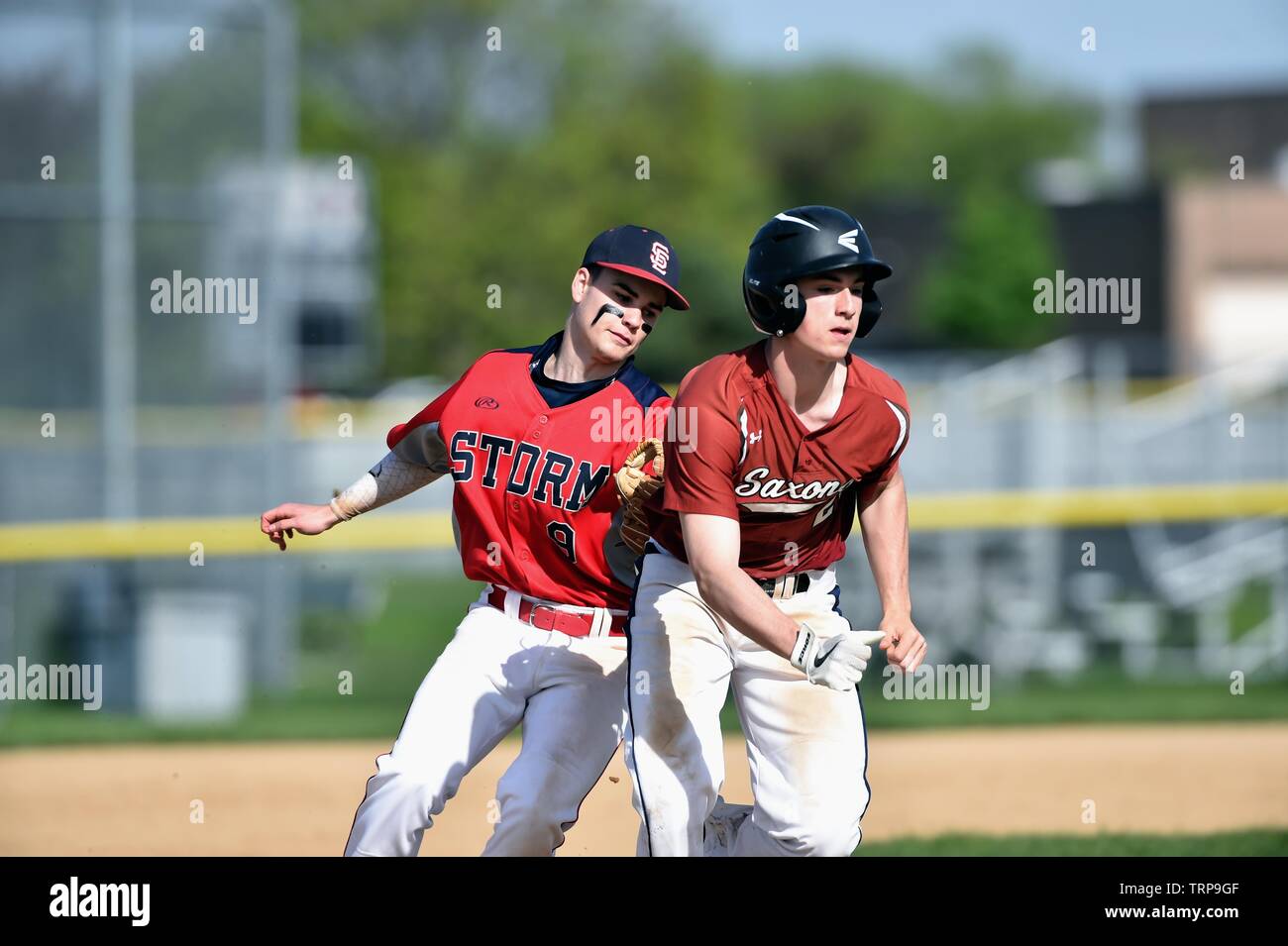 Second baseman applying a tag to an opposing runner during a rundown after the runner was picked off second base. USA. Stock Photo