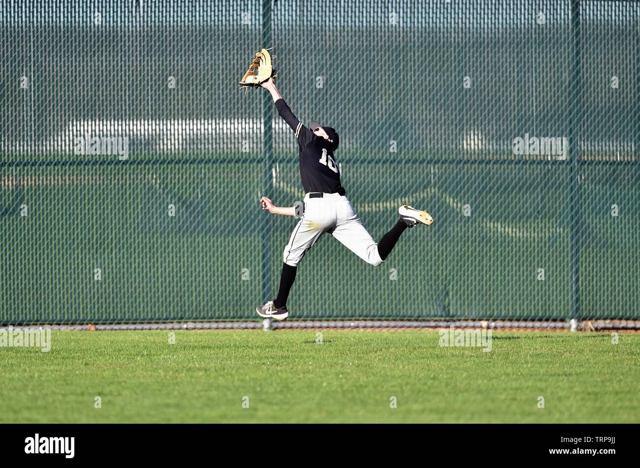 Center fielder making a backhanded, over the shoulder running catch in
