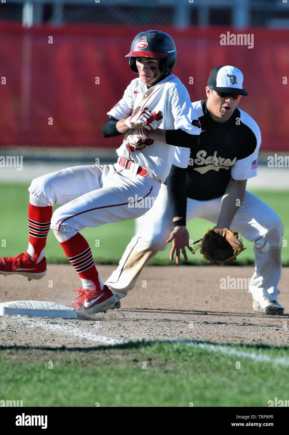 Third baseman stopping a late throw to third as an opposing base runner
