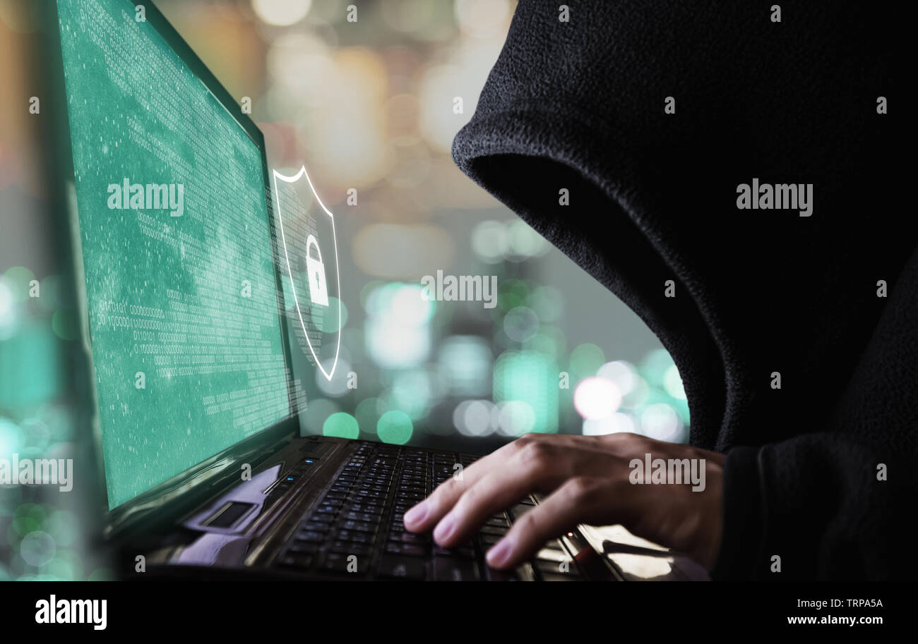 Digital data security system and protection. Anonymous hacker try to hacking on computer laptop Stock Photo