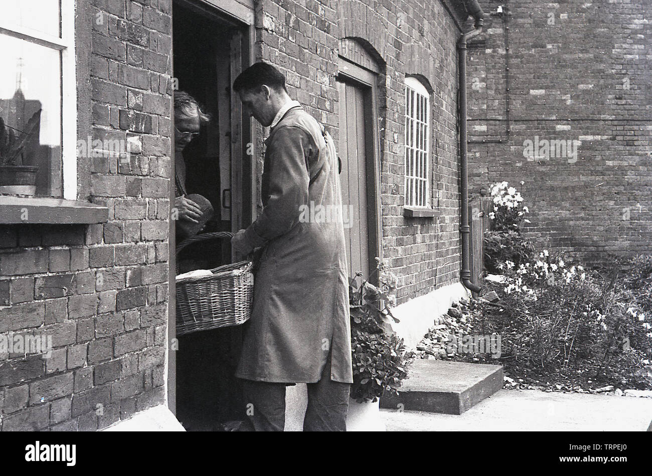 1955, historical, a baker with a basket of bread caling on a customer
