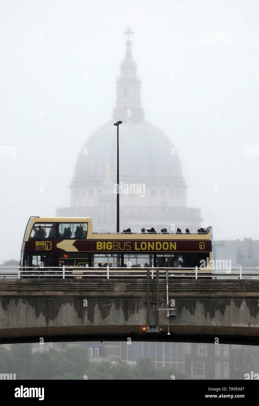 Pic shows Wet weather St Paul’s shrouded in heavy rain as open top buses with brave tourists