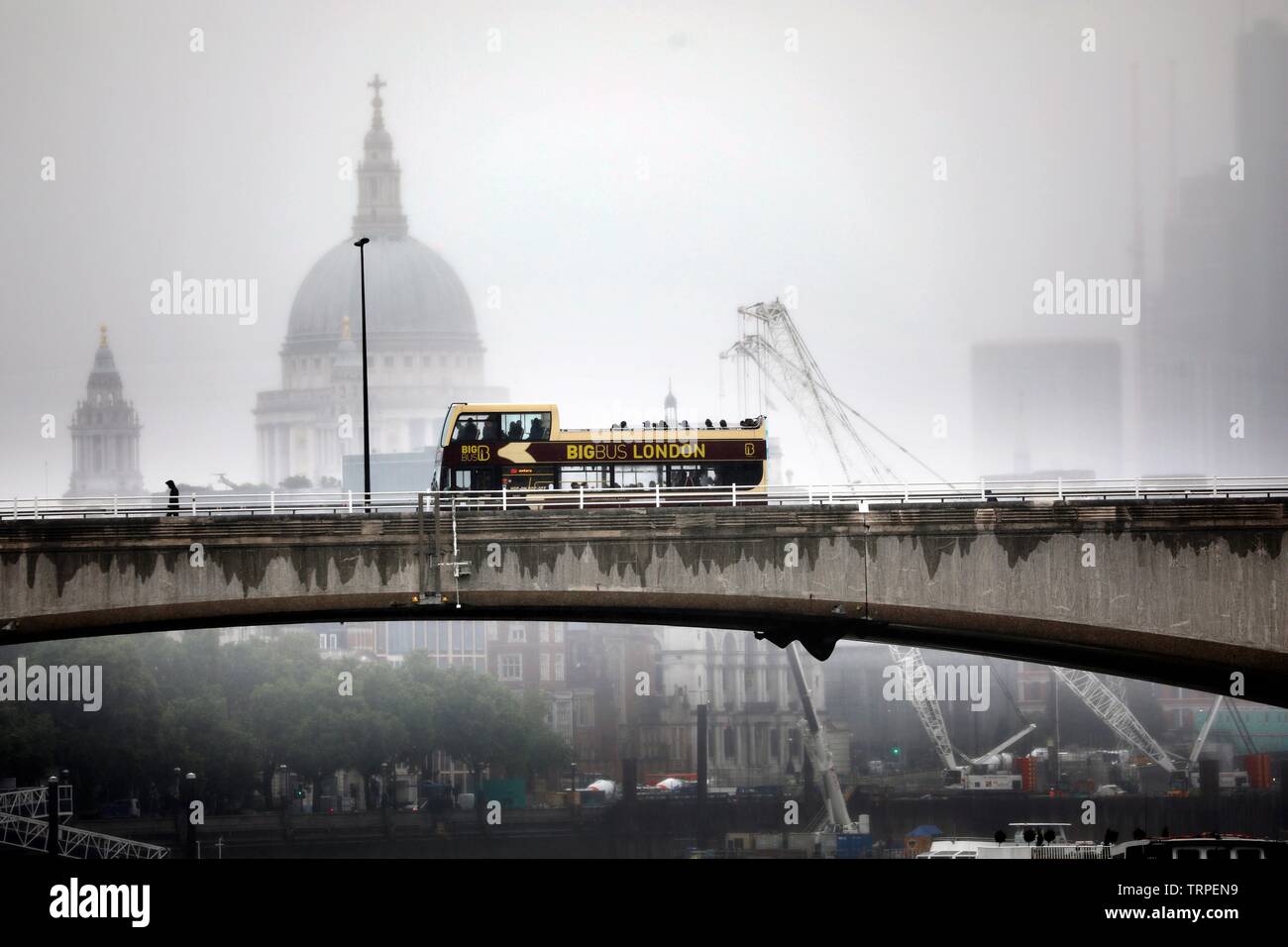 Pic shows Wet weather St Paul’s shrouded in heavy rain as open top buses with brave tourists