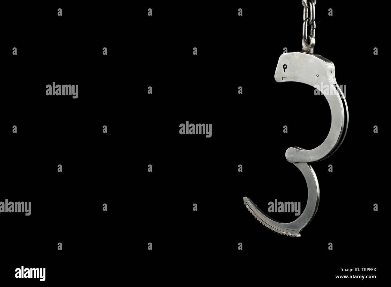 Police handcuffs on a black background with copy space Stock Photo