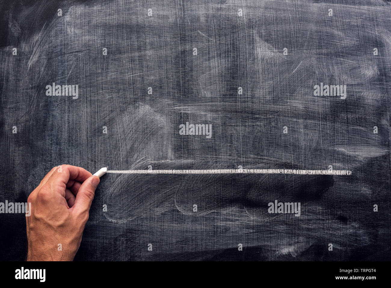 Hand underlining with chalk on school blackboard. Teacher emphasizing something important, mock up copy space Stock Photo