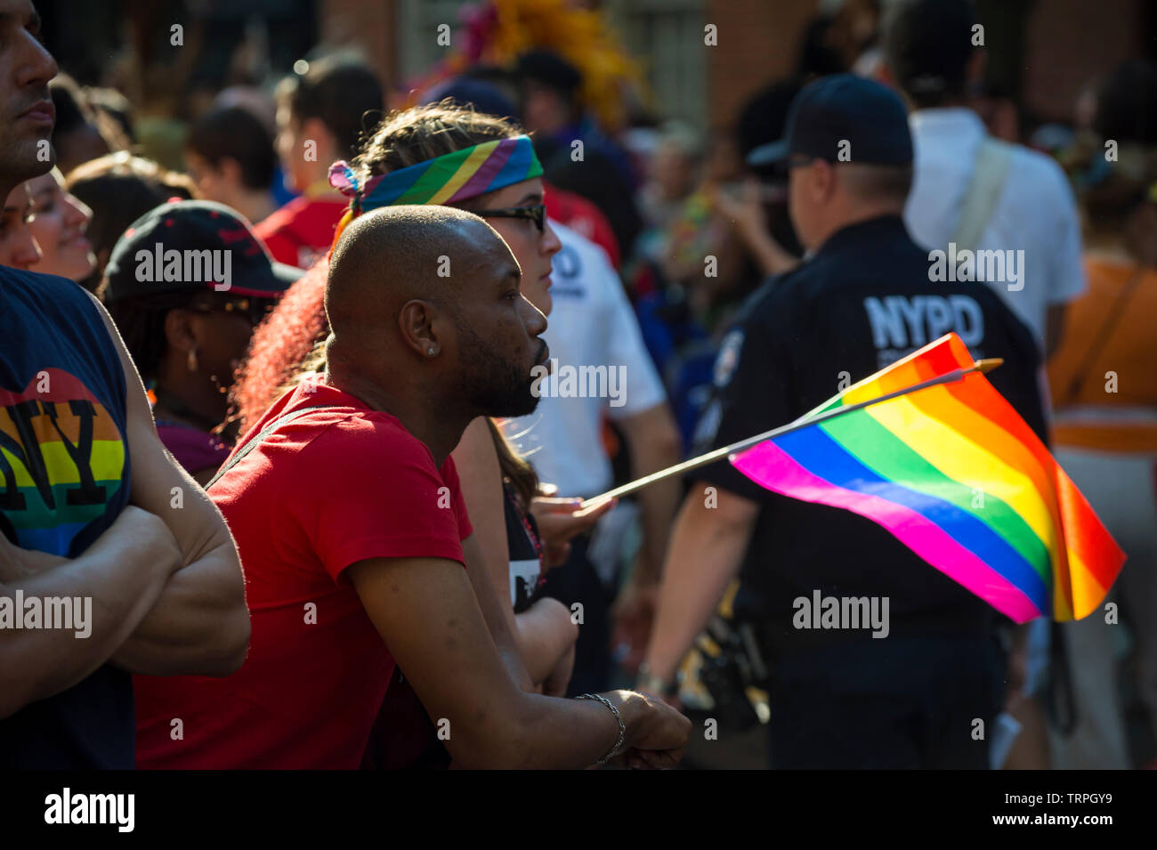 NEW YORK CITY - JUNE 25, 2017: Supporters wave rainbows flags on the sidelines of the annual Pride Parade as it passes through Greenwich Village. Stock Photo