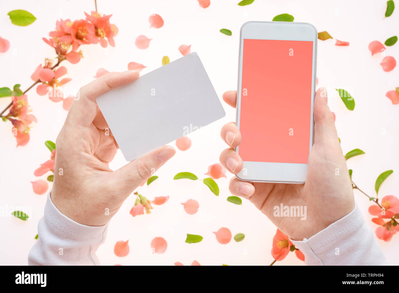 Springtime business card and smartphone in female hands mock up with colorful floral decoration Stock Photo