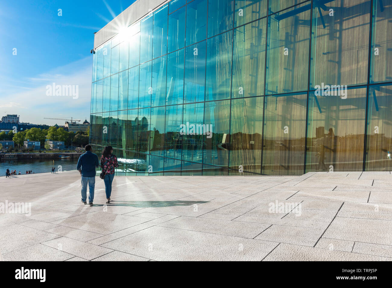 Oslo summer, rear view in summer of a tourist couple descending the vast access ramp leading to the roof of the Oslo Opera House, Norway. Stock Photo
