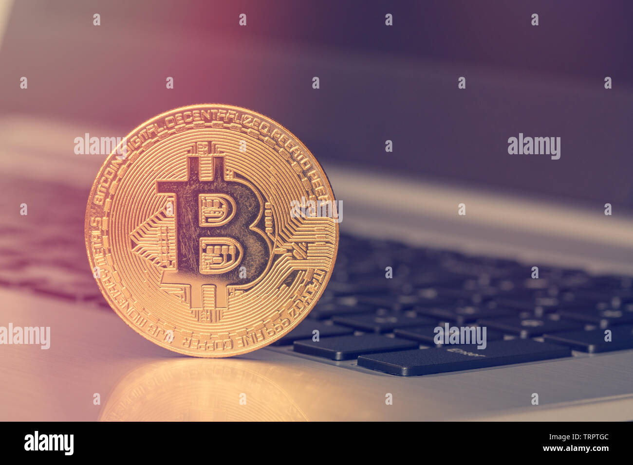Golden Bitcoin coin on the laptop keyboard. Filtered image Stock Photo ...