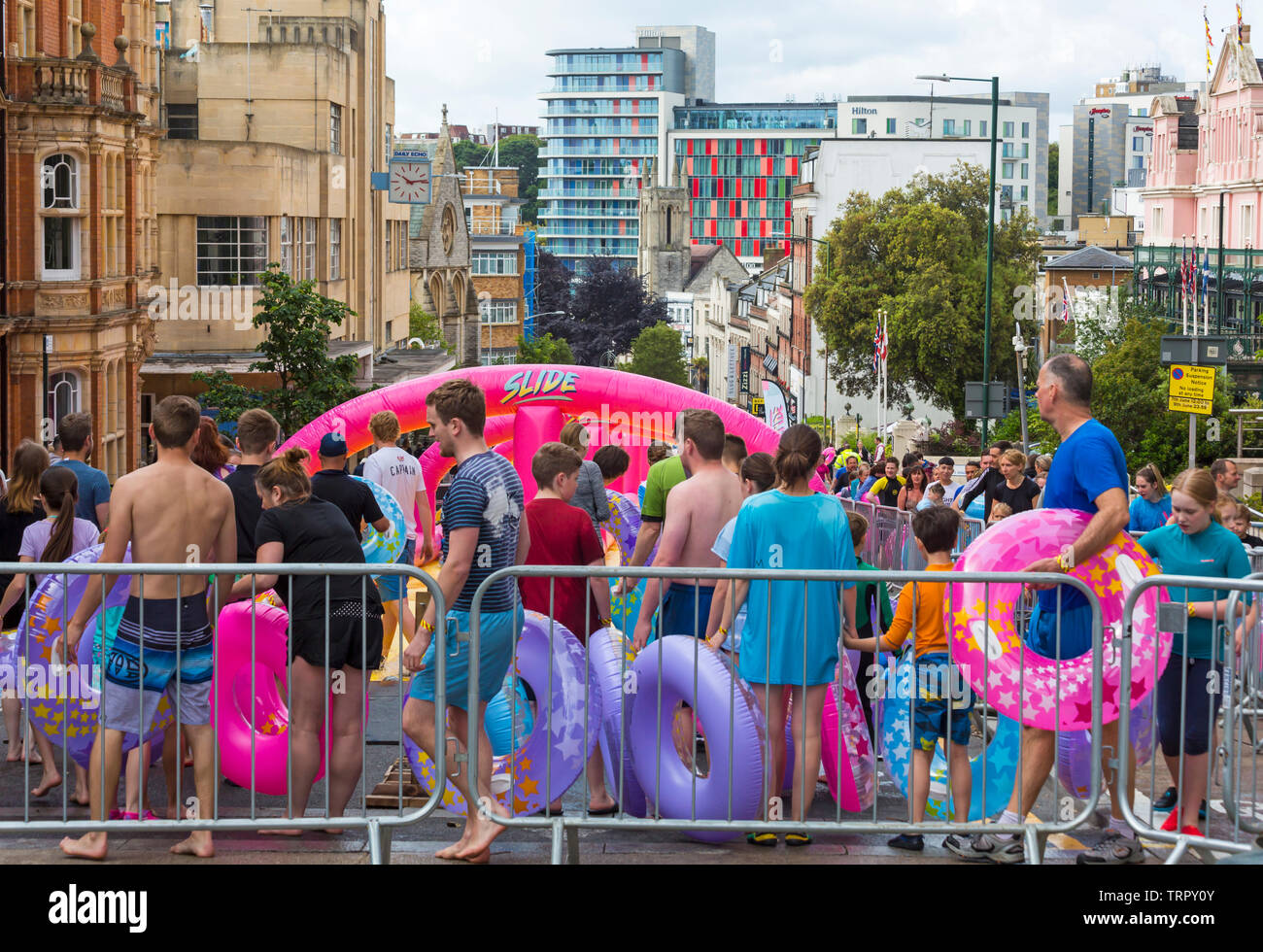 queuing at the top to have a go on giant waterslide, water slide, at Bournemouth, Dorset UK in June Stock Photo