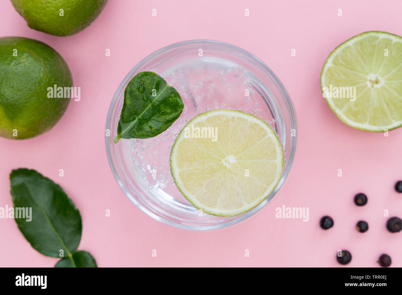 Gin tonic cocktail drink in glass on summer pink background Stock Photo