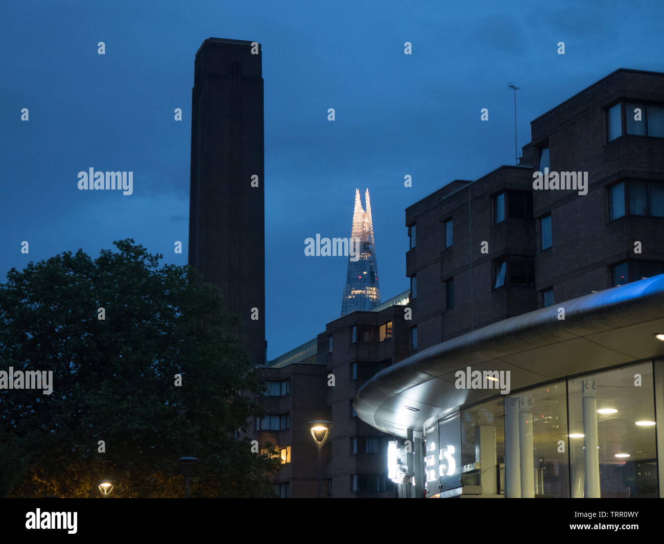 The top of the Shard seen next to the tower of Bankside Power Station (Tate Modern) at dusk, the Shard lit up Stock Photo