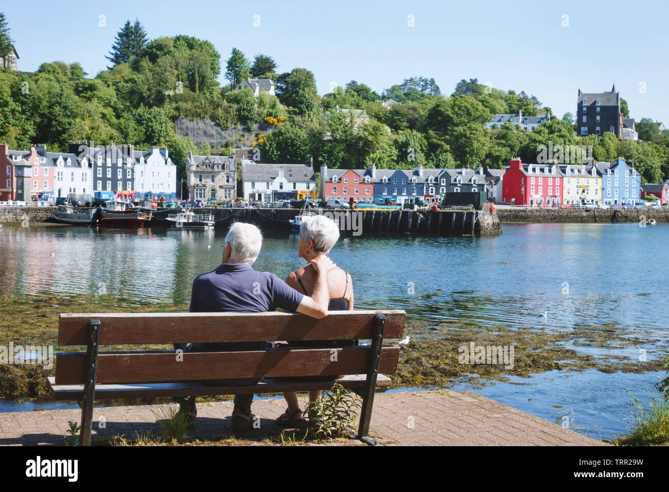 Couple on bench in Tobermory Harbour Stock Photo