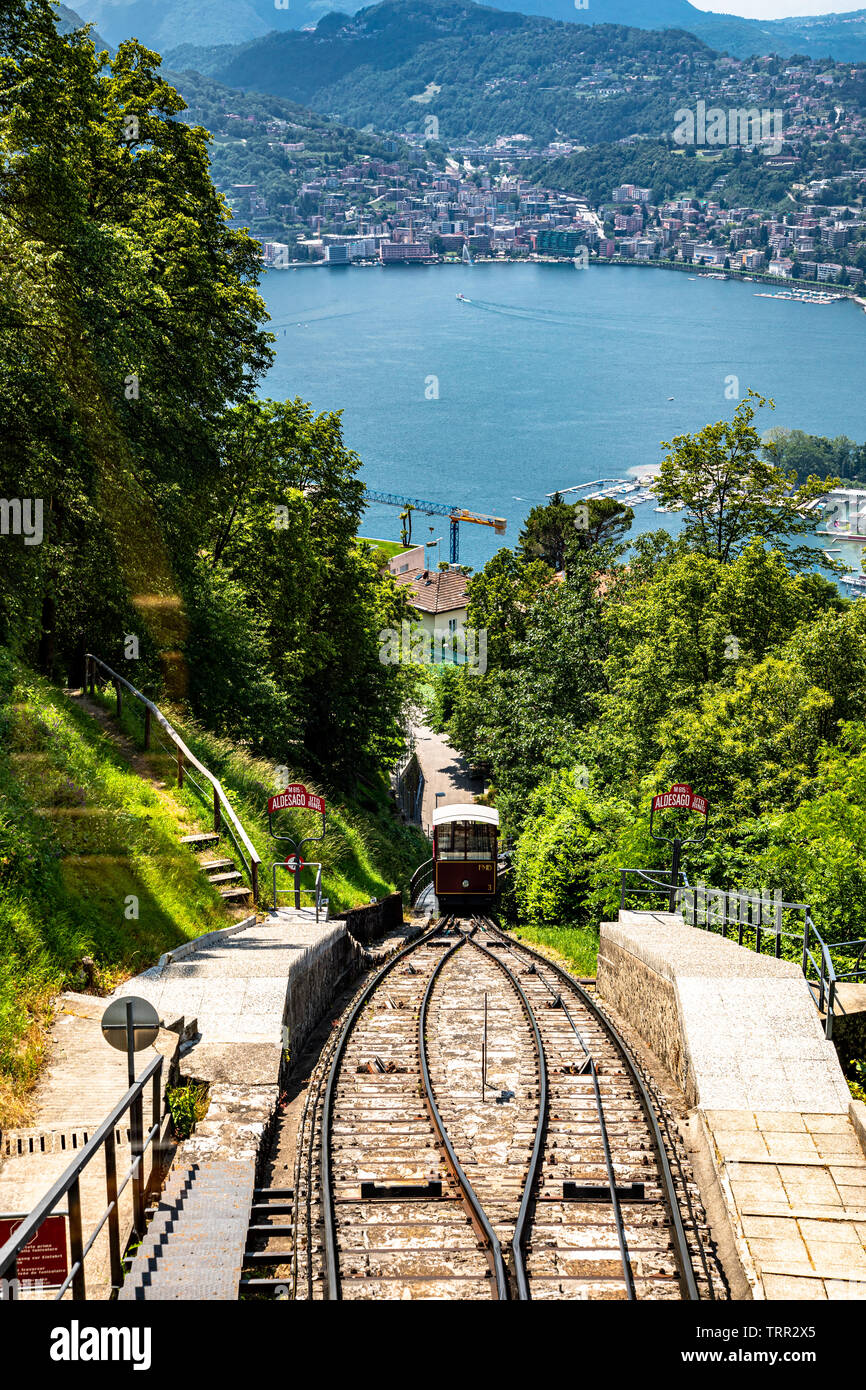 Monte Bre, Switzerland - June 08, 2019 View of the Mont Bre funicular going down with lake Lugano at the background Stock Photo