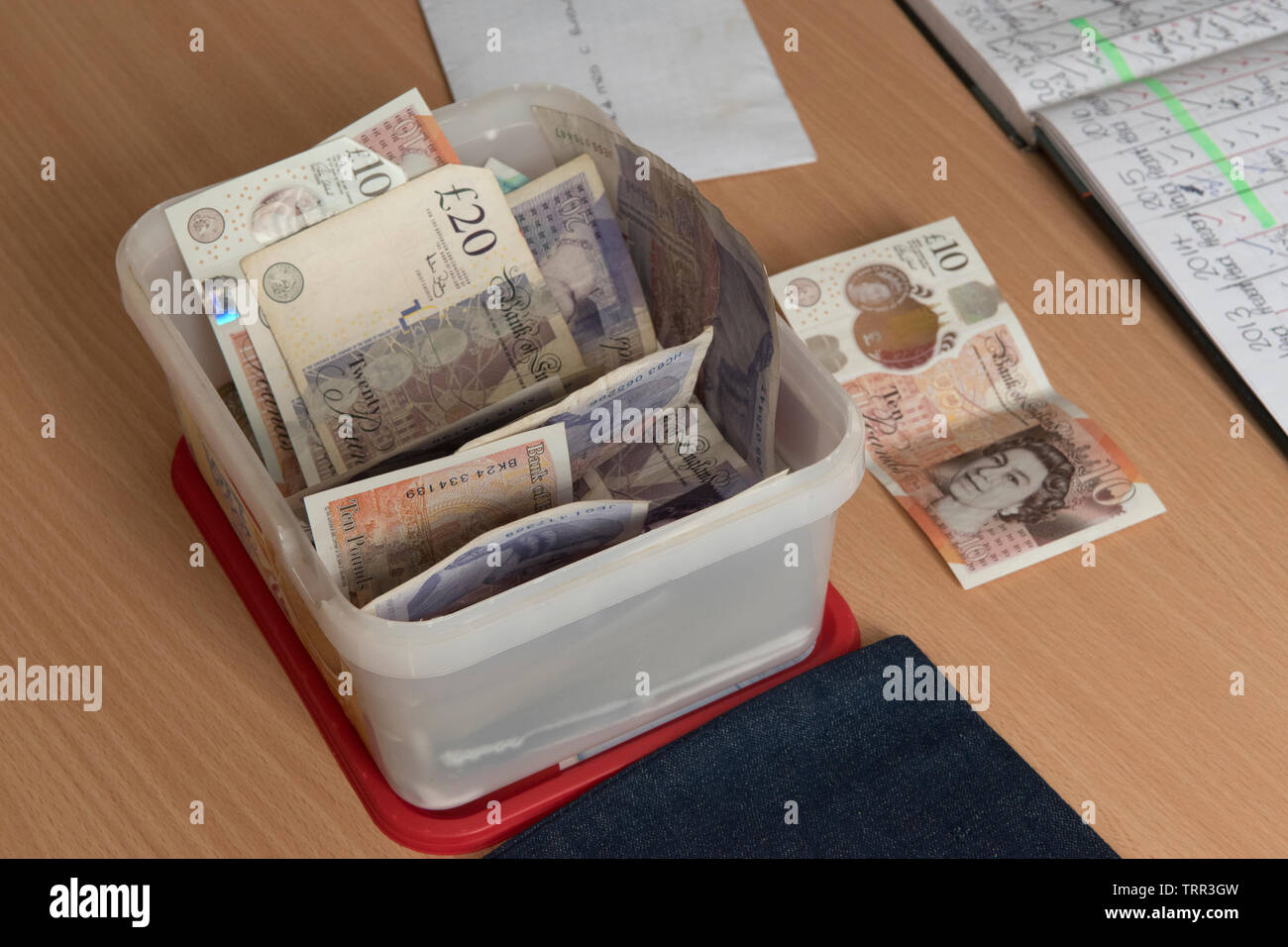 Money £20.00 and £10.00 notes in a plastic container 2010s Village group pay their annual subscription, HOMER SYKES Stock Photo