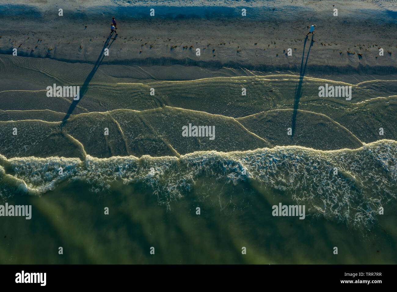 Ariel view of woman running along beach as waves roll in St. Pete Beach Florida. Stock Photo