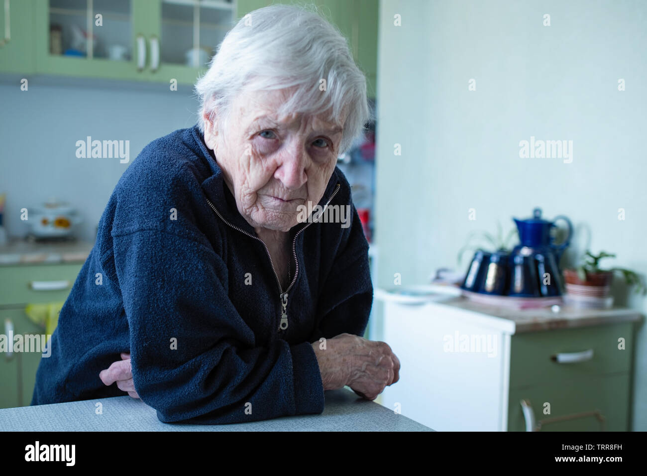 Frowned the old lady is in his house. Stock Photo