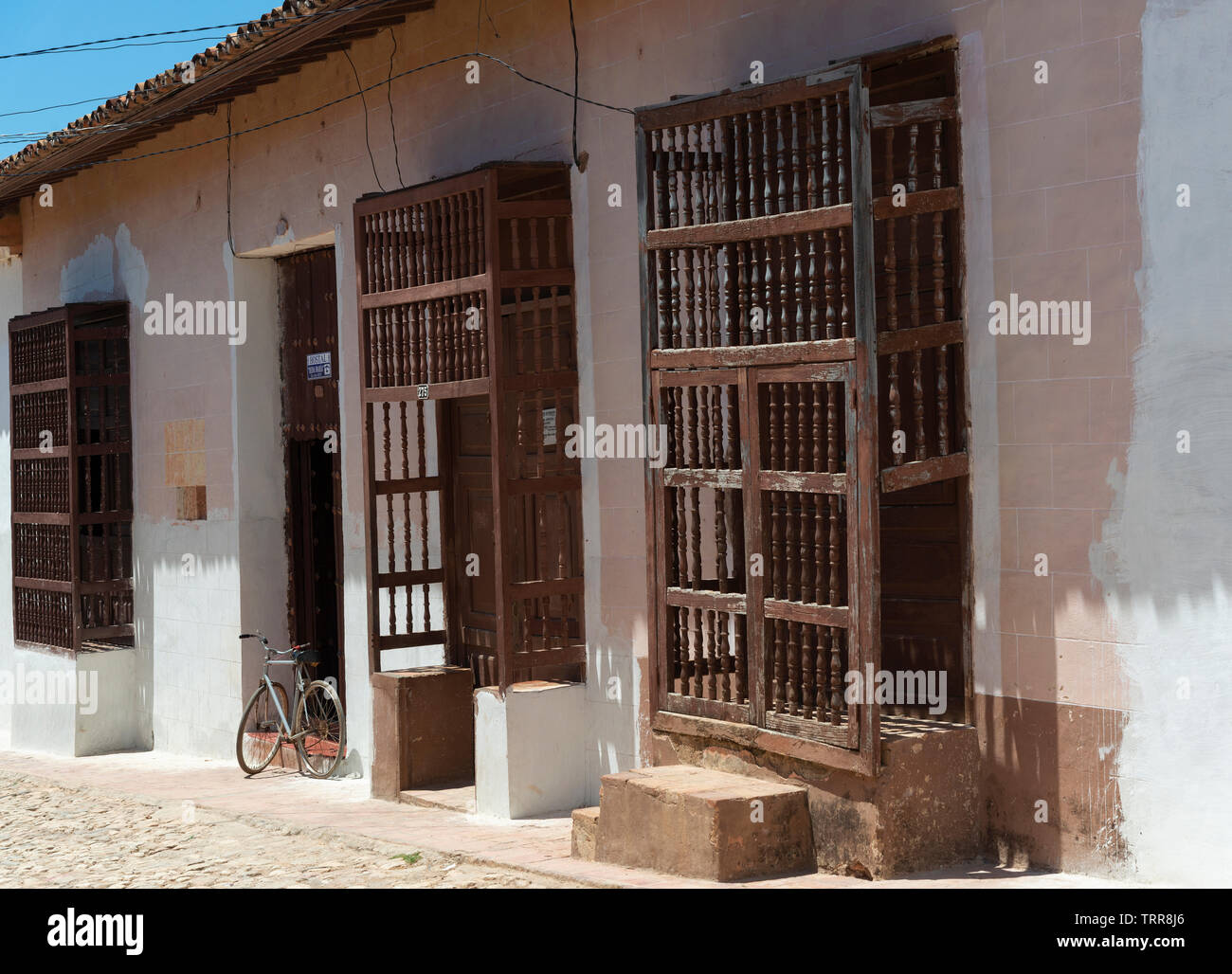 Old traditional house with wooden windows with bars in the centre of