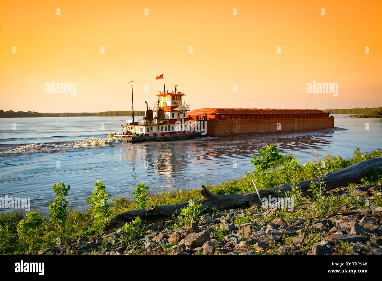 View from the riverbank of a loaded barge navigating the mighty 