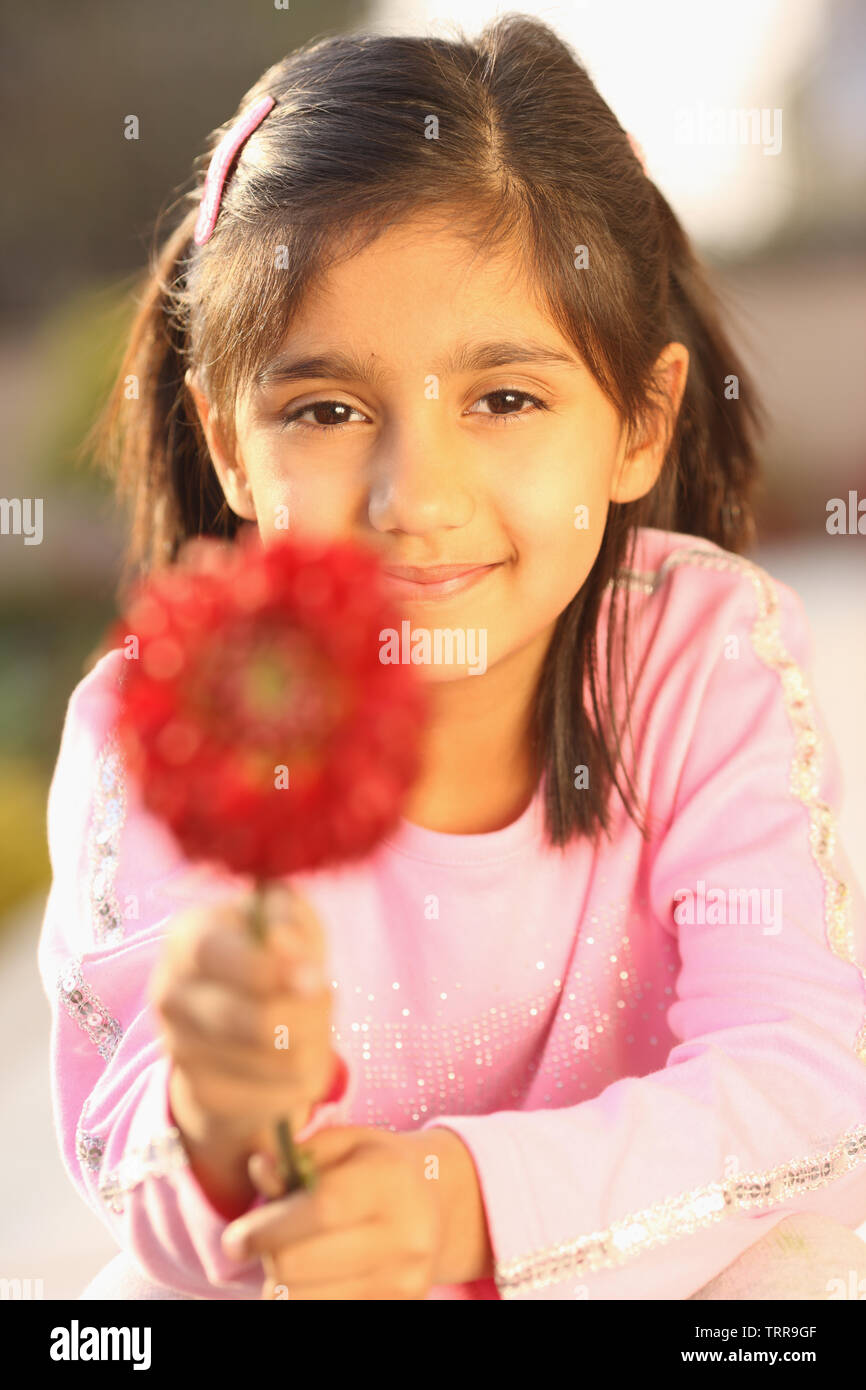 Portrait of a girl holding a flower Stock Photo - Alamy