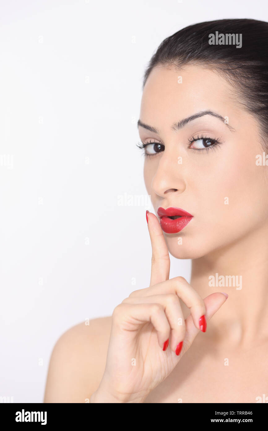 Close-up of a woman with a finger on lips Stock Photo