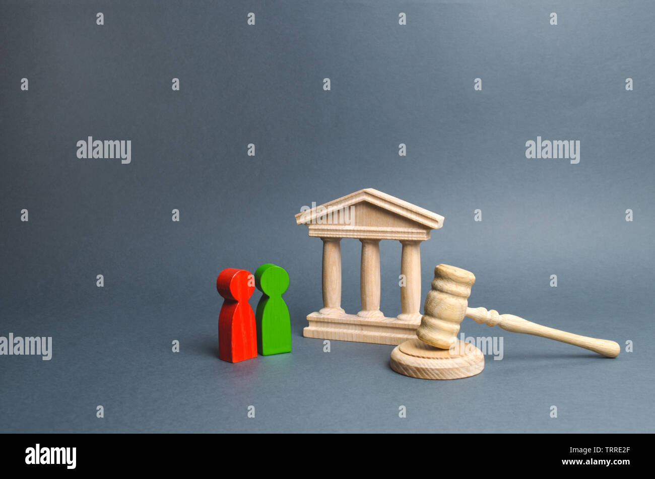 Two figures of people opponents stand near the courthouse and the judge's gavel. Conflict resolution in court, claimant and respondent. Court case, se Stock Photo