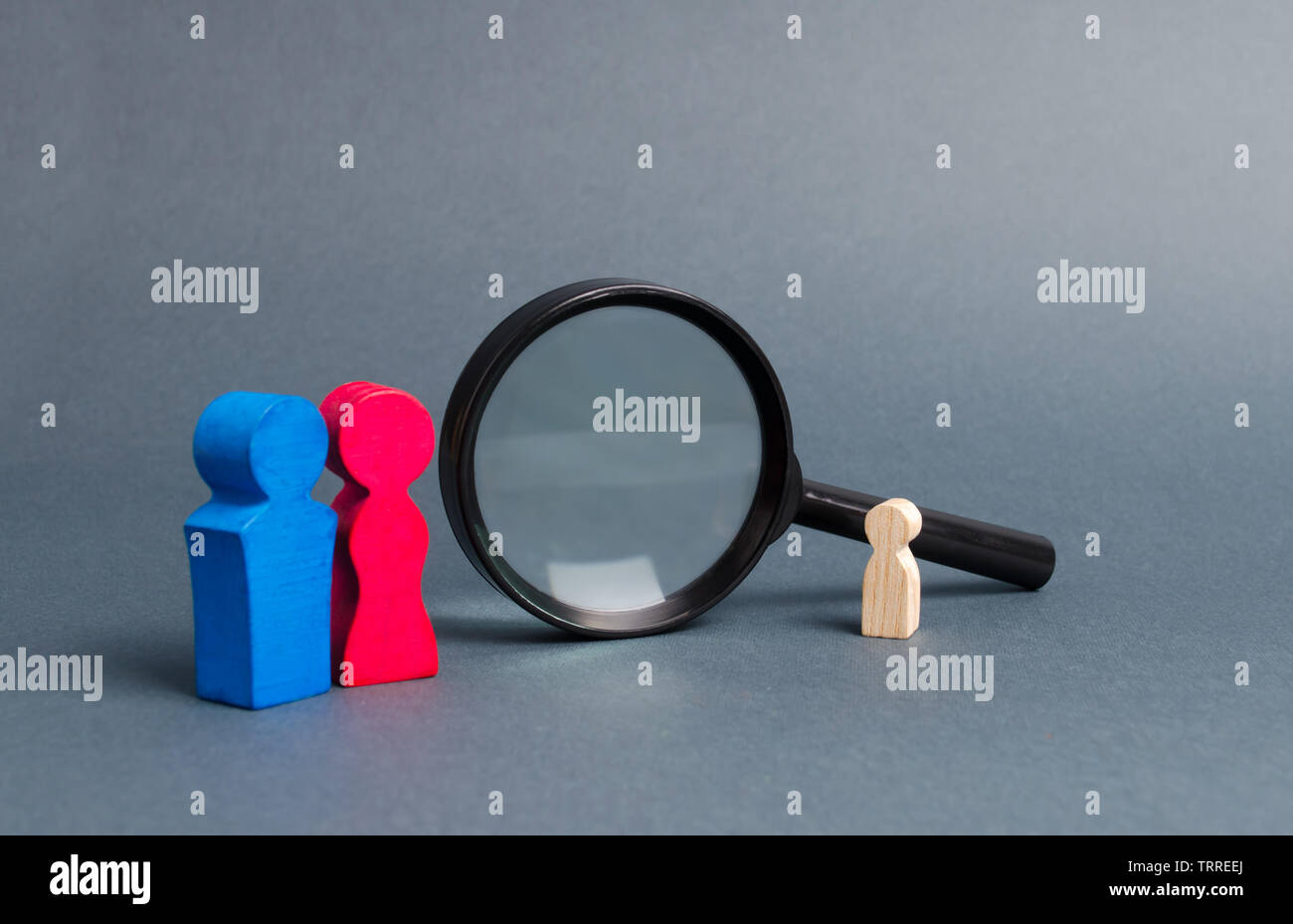 Parents in search of a lost child or adoption of a child near the magnifying glass. The concept of finding a child, the adoption of children. Mother l Stock Photo