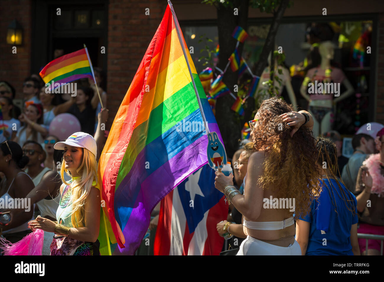 NEW YORK CITY - JUNE 25, 2017: Participants wave rainbow and Puerto Rican flags as the Gay Pride Parade as it passes through Greenwich Village. Stock Photo