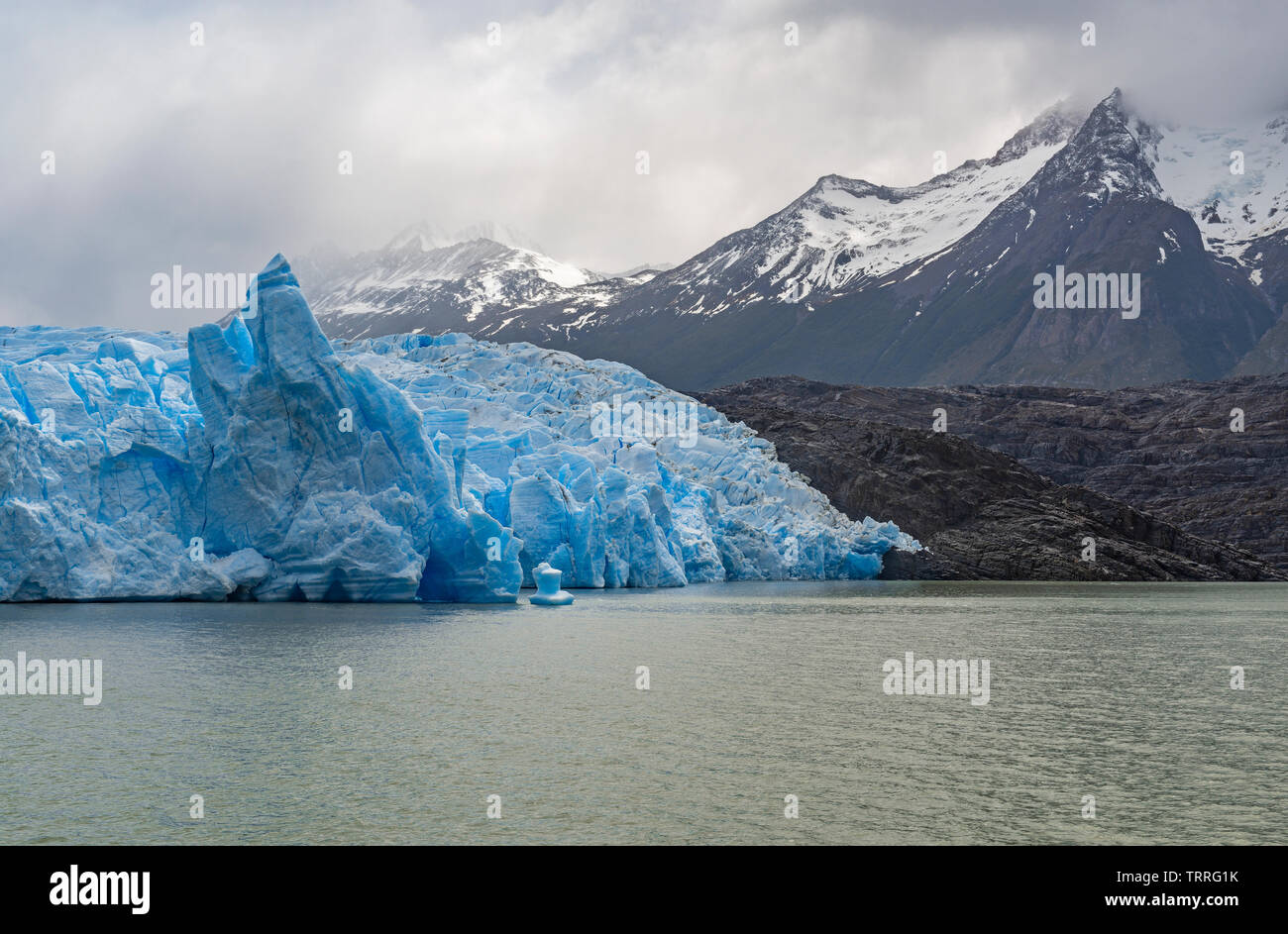 The blue ice Grey Glacier with Andes peaks in the snow by Grey Lake, Torres del Paine national park, Patagonia, Chile. Stock Photo