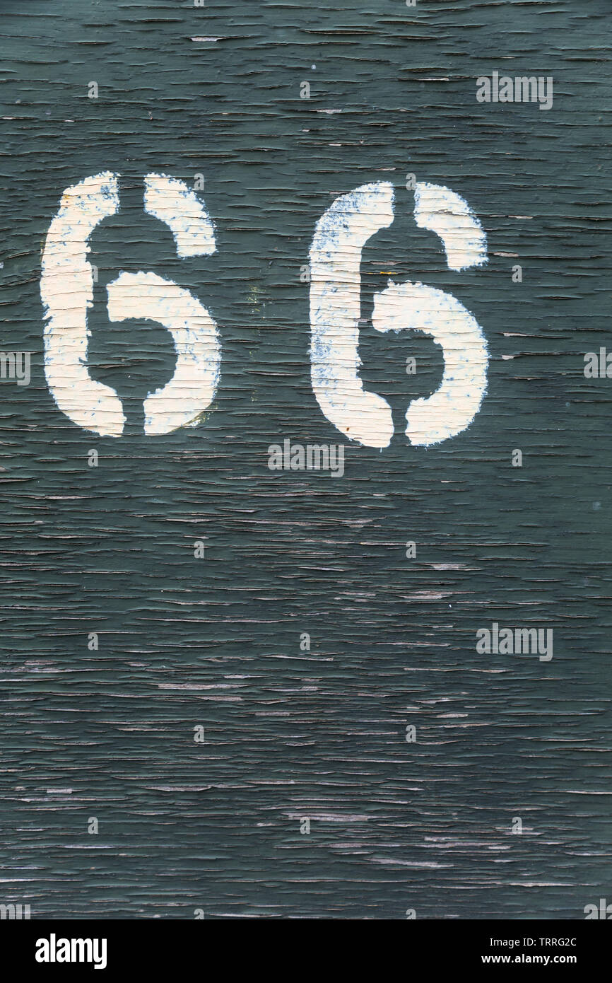 Stencilled marking numbers 66 painted in white on green wooden side panel of LMS railway goods wagon van no 4166 at Didcot Railway Centre, Oxfordshire Stock Photo