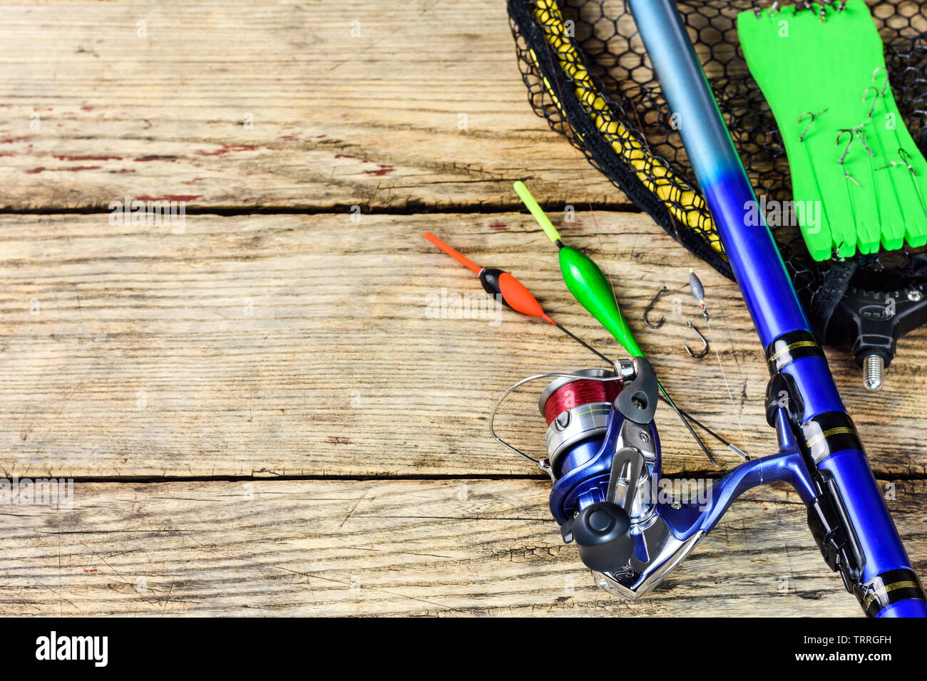 Fishing tackle. Fishing rod, floats, fishing hooks and landing net on old  wooden background with free space for text Stock Photo - Alamy