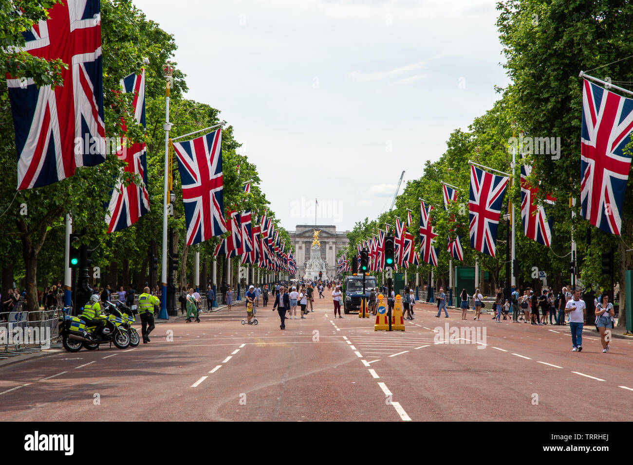 London, England, UK - June 1, 2019: Union Jack flags fly along The Mall ahead of a ceremonial event in central London, while crowds of tourists walk o Stock Photo