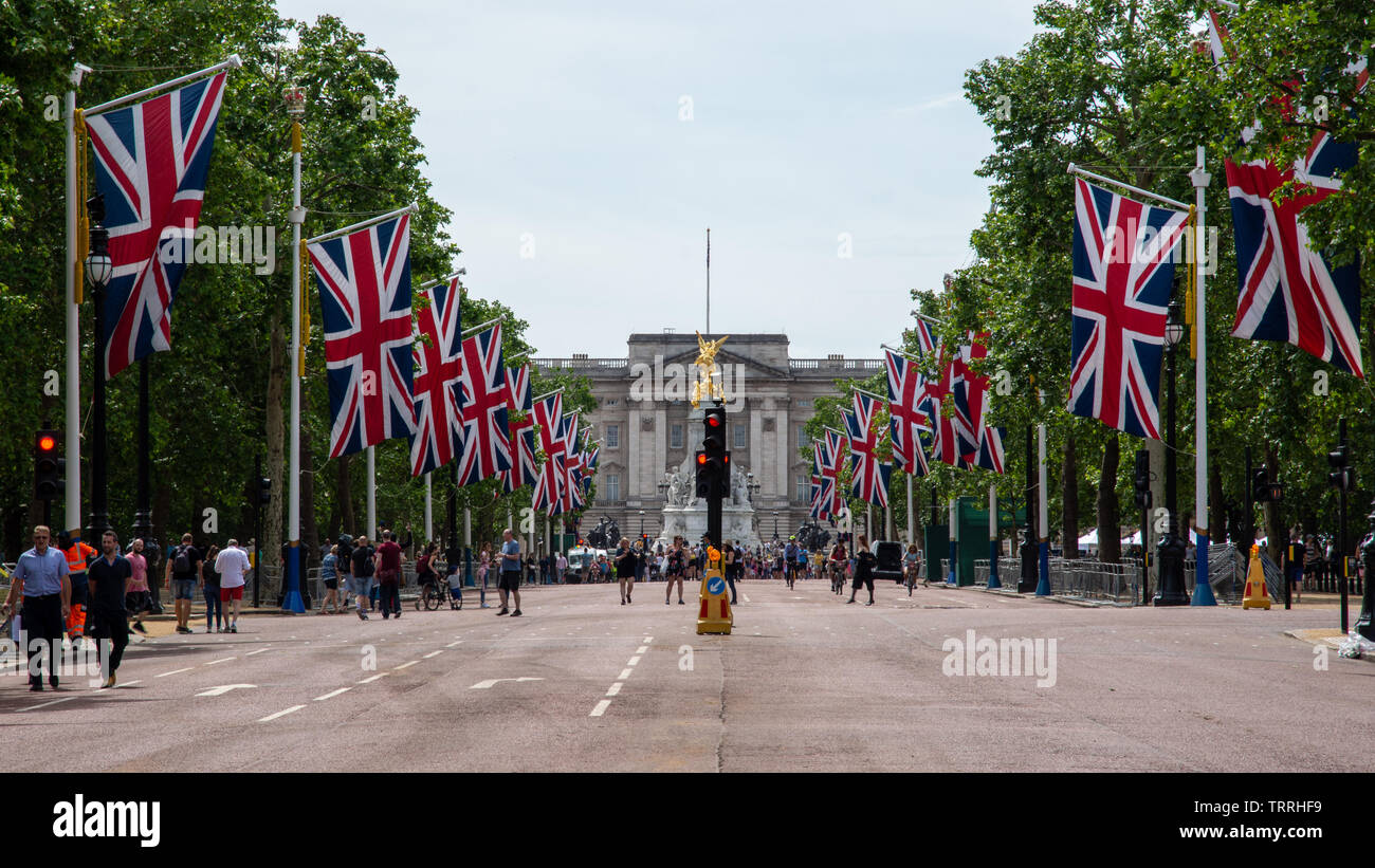 London, England, UK - June 1, 2019: Union Jack flags fly along The Mall ahead of a ceremonial event in central London, while crowds of tourists walk o Stock Photo