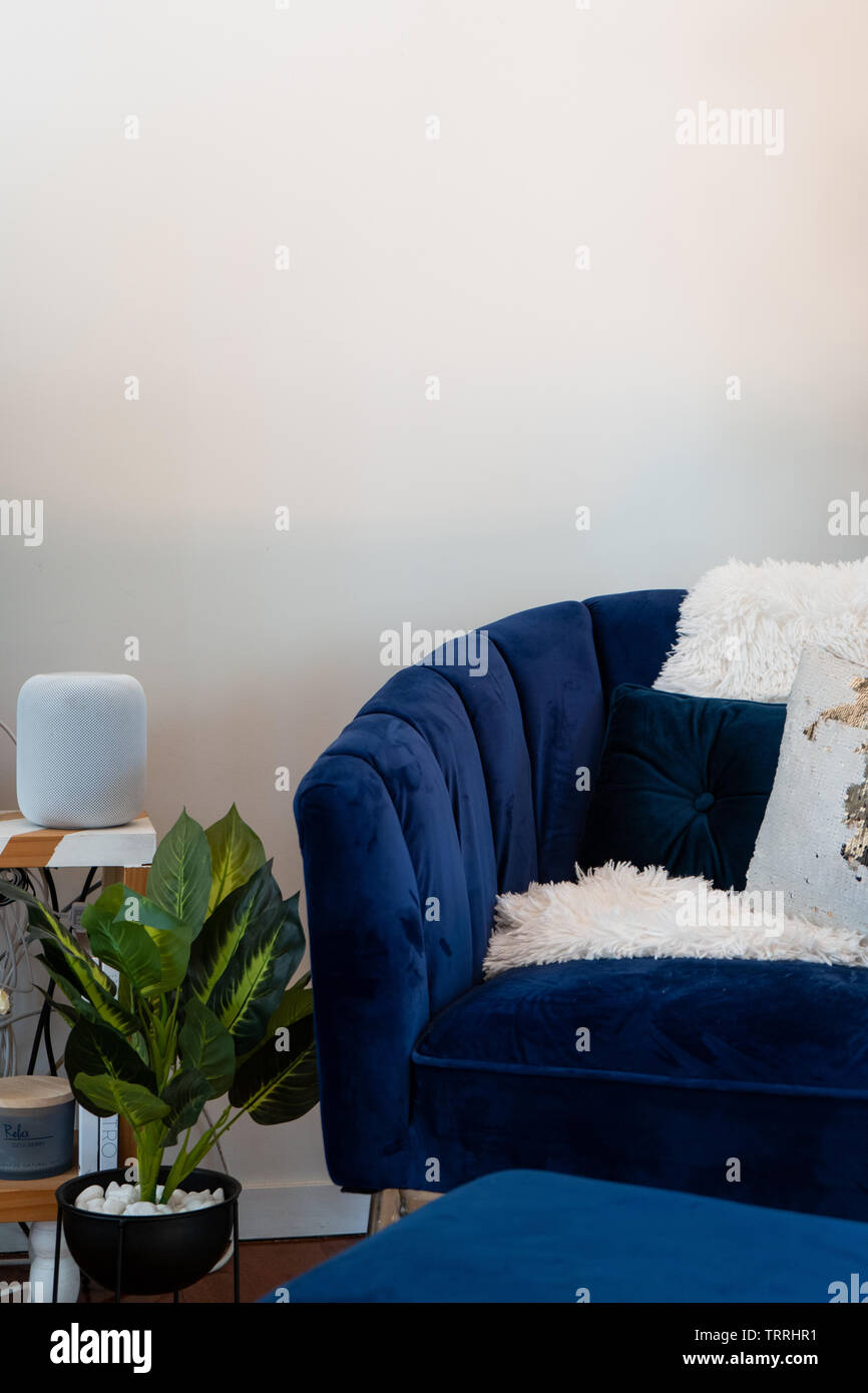 Apple home pod in living room setting with blue velvet chair Stock Photo