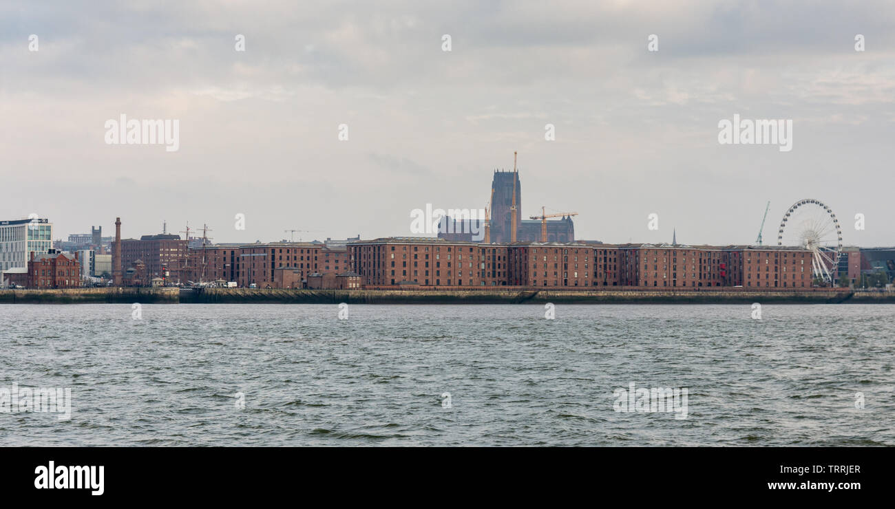 Liverpool, England, UK - November 4, 2015: Liverpool's gothic cathedral towers over the city skyline and warehouses of the Albert Dock as seen from th Stock Photo