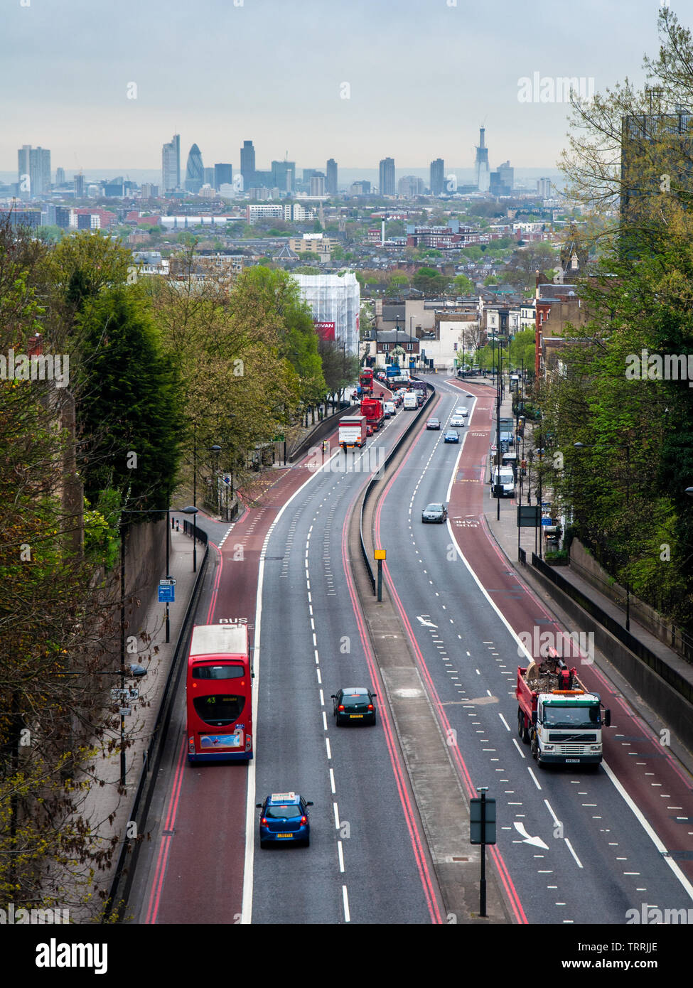 London, England, UK - April 13, 2011: Traffic flows along the Archway Road in the North London suburbs, with the skyline of the City of London busines Stock Photo