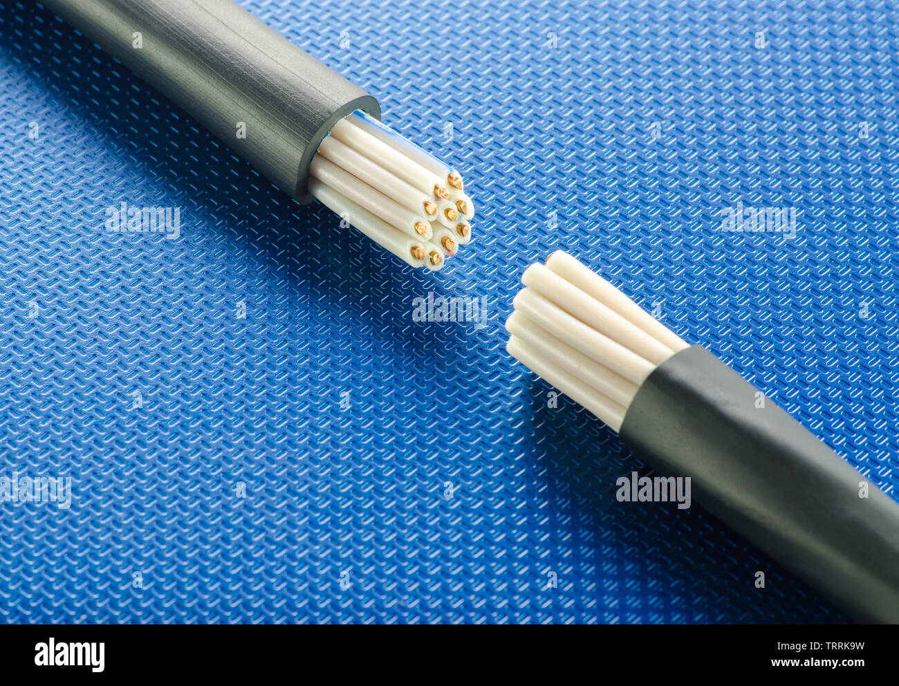 Cross-section of two control cables on blue ribbed technological background Stock Photo