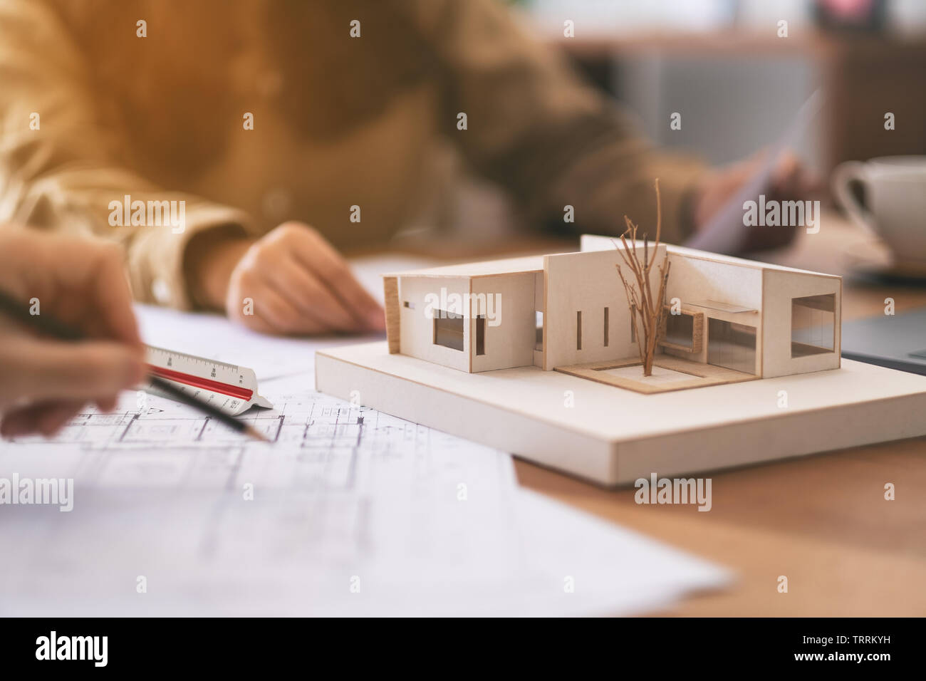 Group of an architect working and discussing about an architecture model together with shop drawing paper on table in office Stock Photo