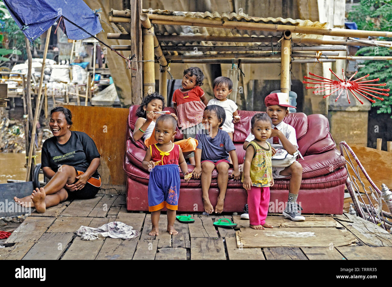 jakarta, dki jakarta/indonesia - november 16, 2009: poor squatter people enjoying life on a couch in  kampung melayu at the banks of ciliwung river Stock Photo