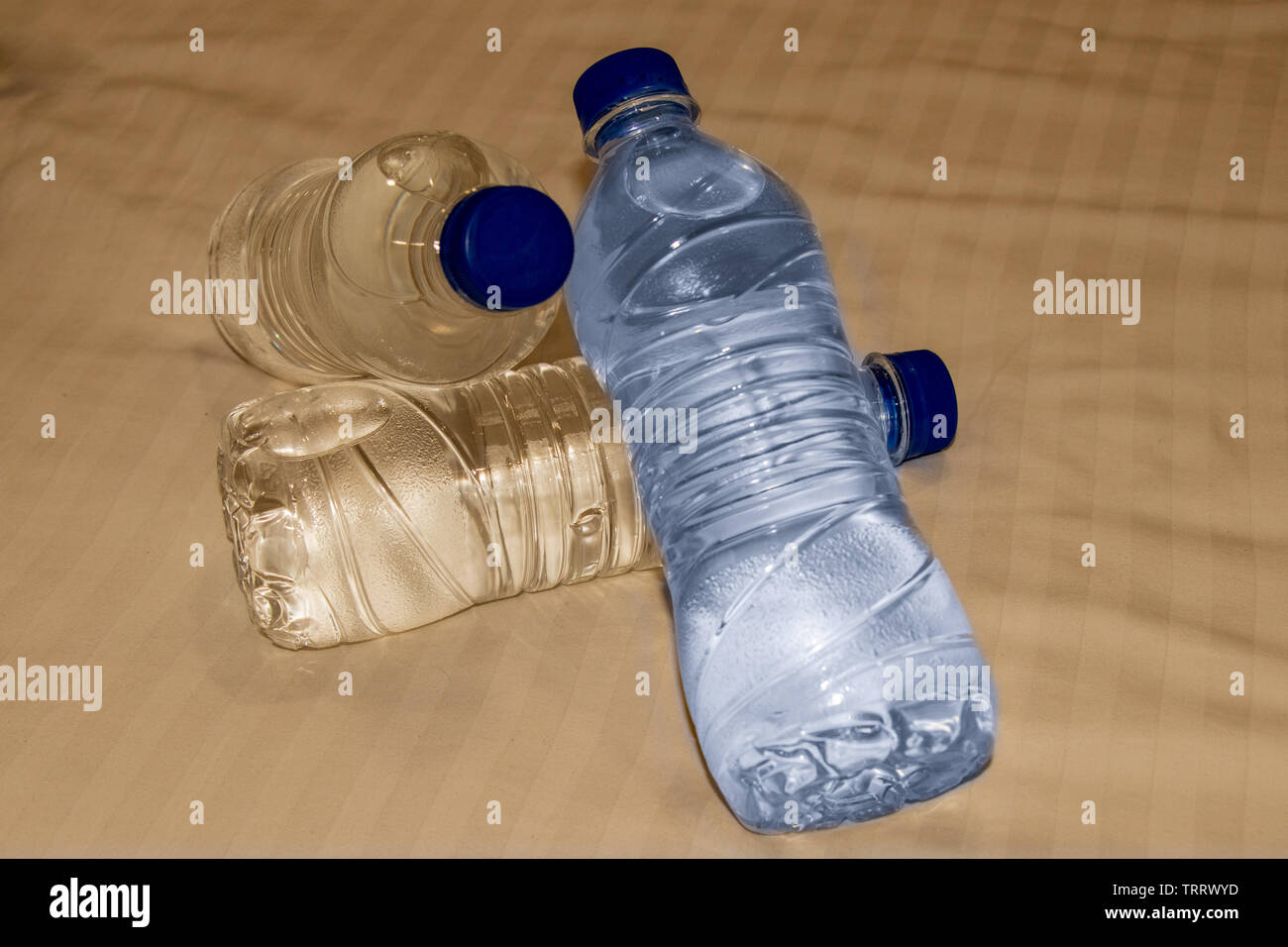 Plastic water bottles lying on bed. Stock Photo