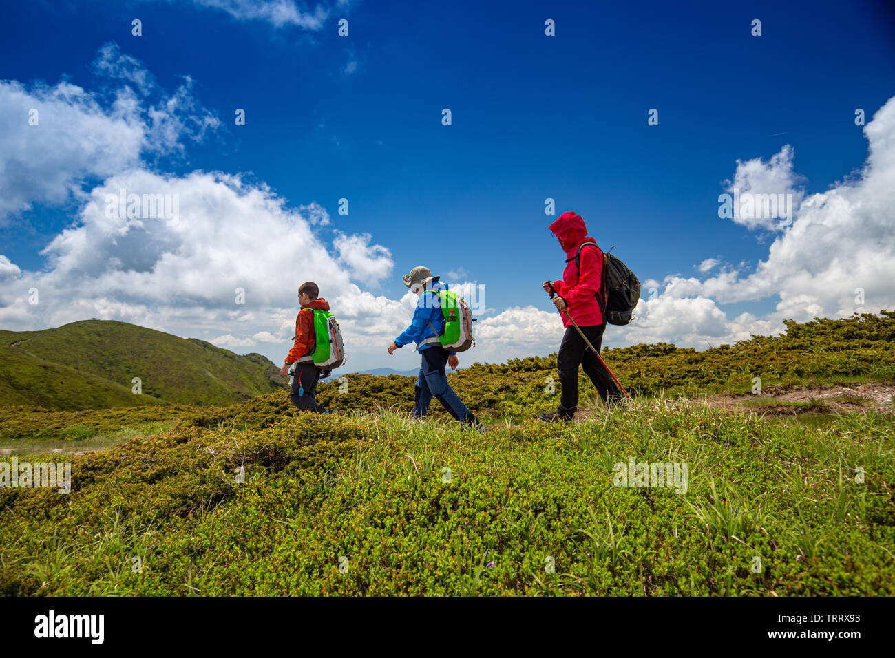 Mom with two kids hiking in mountains Stock Photo