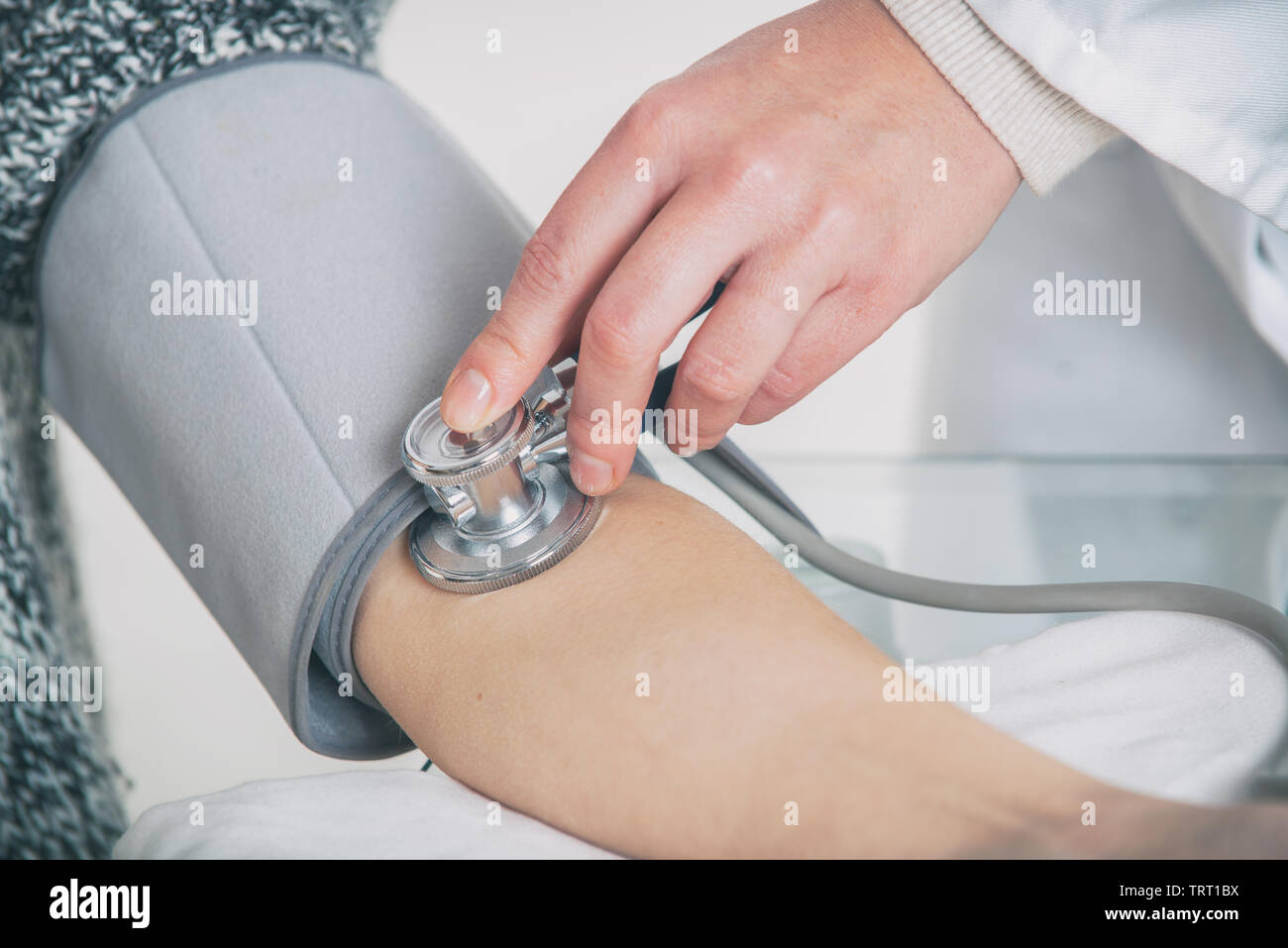 Doctor cardiologist measuring blood pressure of female patient in hospital office appointment Stock Photo