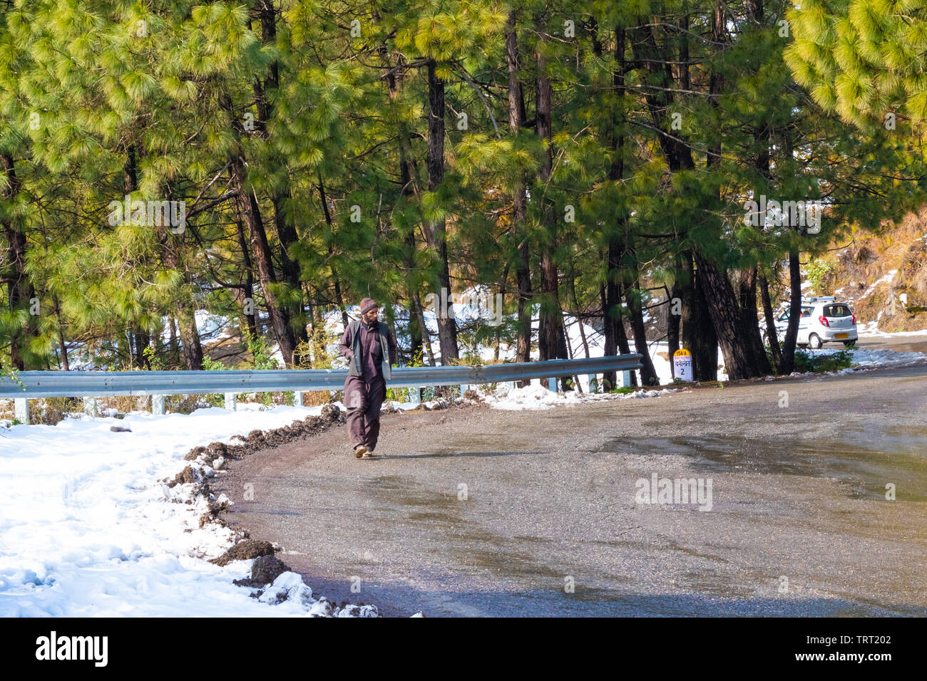 Banikhet, Dalhousie, Himachal Pradesh, India - January 2019. After consequences of heavy snowfall, local person walk on the road. Stock Photo