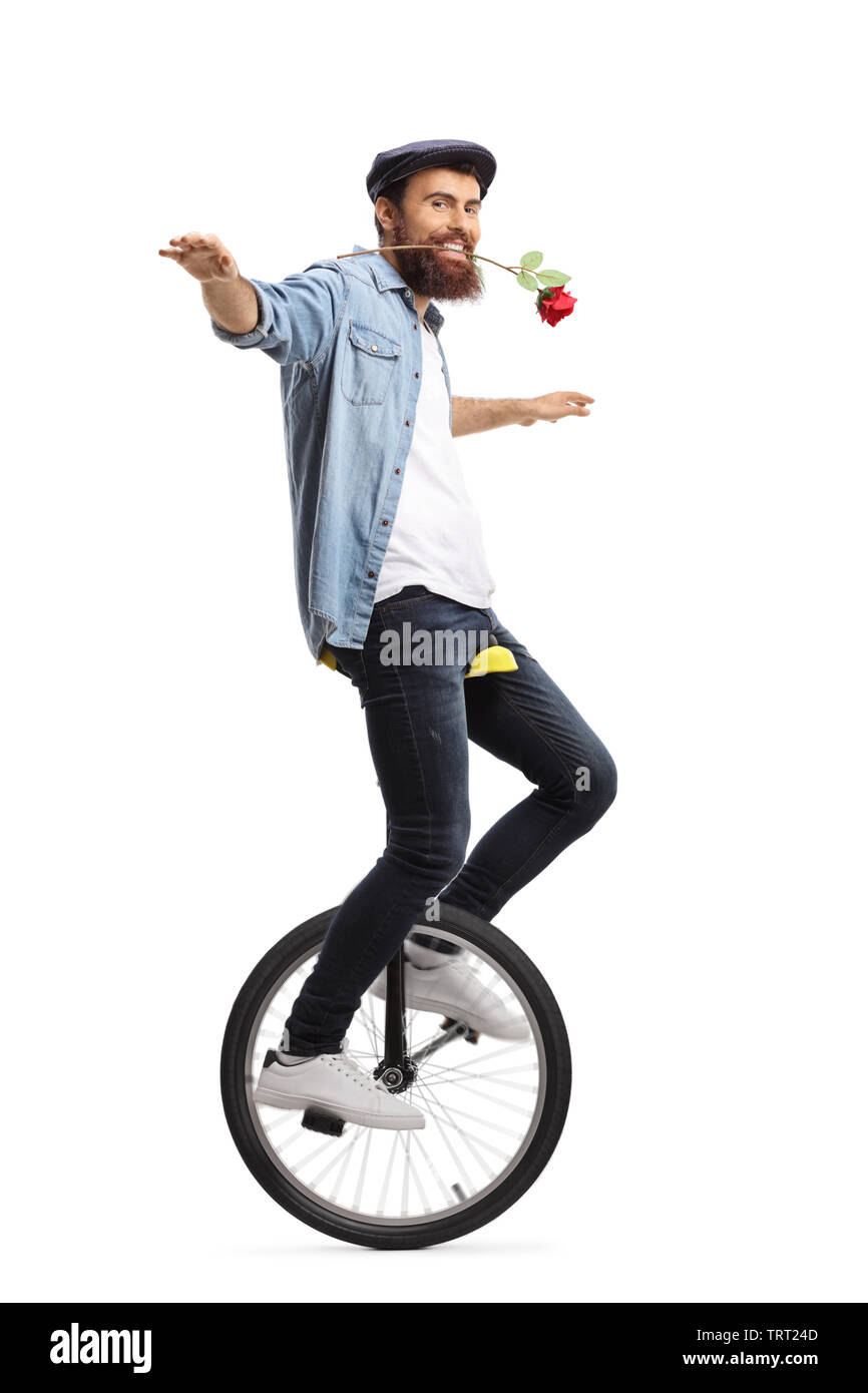 Full length shot of a bearded guy on a unicycle holding a red rose with his mouth isolated on white background Stock Photo